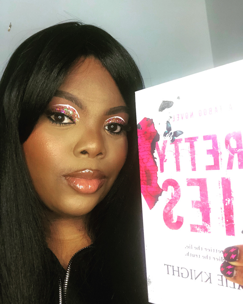 Natalie Knight holding a paperback copy of her novel Pretty Lies